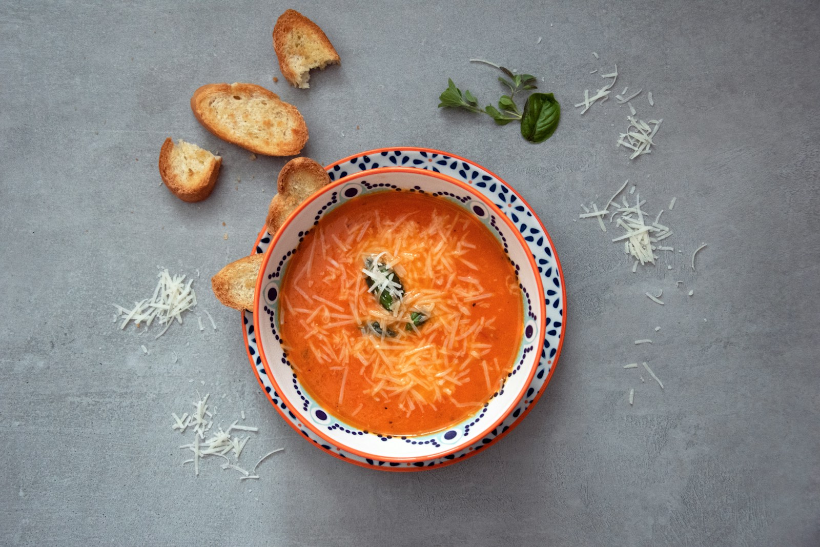 orange soup on white and blue ceramic bowl